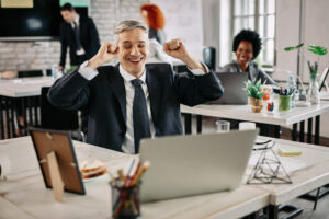 happy businessman celebrating success while working computer office